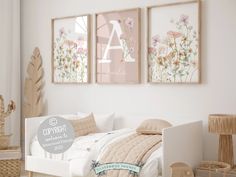 a white bed sitting next to two pictures on the wall