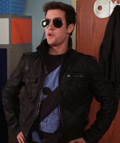 a man wearing sunglasses standing in front of a closet