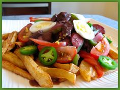 a white plate topped with fries and vegetables