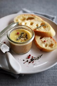 a plate topped with bread and a jar filled with liquid next to it on top of a table