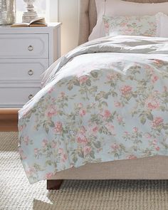 a bed with pink flowers on it in a bedroom