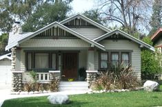 a house that is in the middle of some grass and rocks on the front lawn