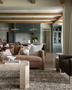 a living room filled with furniture and lots of wood beams on the ceiling above it