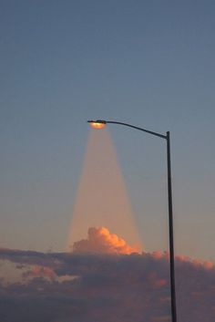 a street light on a pole with clouds in the background