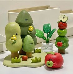 there are many small plastic fruits and vegetables in the shape of trees with faces on them