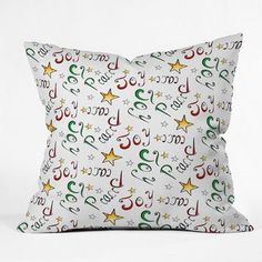 a white pillow with colorful stars and numbers printed on the front, sitting against a white background