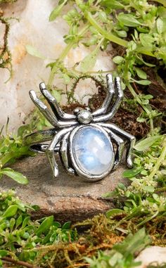 The Blue Moonstone Stainless Steel Spider Ring is made from hand-carved genuine Blue Moonstone crystals. Artfully forged with stainless steel and offering complete adjustability, these rings are designed to fit all sizes and styles. Blue Moonstone is a healing stone that is brimming with feminine energy. This is a gentle stone that gives off tranquil and healing properties that can surround you like a hug. You may hear Blue Moonstone referred to as the Stone Of New Beginnings. That is because this stone has healing properties that can help us shed old fears, bad habits and instabilities in order to move forward with faith and courage. One of the most striking things about Blue Moonstone is its beautiful, blue sheen. This is caused by something known as adularescence or schiller. All Moonst Adjustable Spiritual Moonstone Ring, Witchcraft Energy, Mystical Moon-shaped Sterling Silver Moonstone Ring, Handmade Moon-shaped Spiritual Crystal Ring, Spiritual Adjustable Moon-shaped Moonstone Ring, Moon-shaped Moonstone Healing Jewelry, Selenite Jewelry, Spider Ring, Handmade Crystal Jewelry