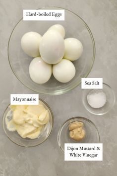 eggs, mayonnaise, and other ingredients in bowls on a counter top with labels