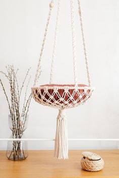 a macrame plant hanger with tassels and beads hanging from it