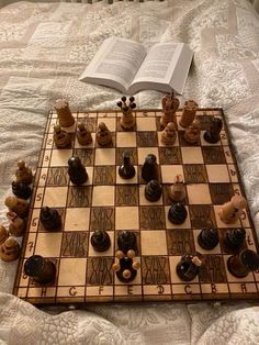 a chess board and book on a bed