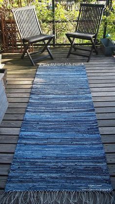 a blue rug on a wooden deck with two chairs