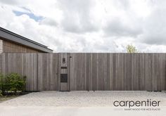 an empty parking lot in front of a wooden fence with the words carpentier on it