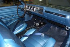 the interior of an old car with blue leather seats