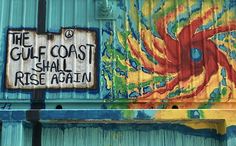 graffiti painted on the side of a building with a sign that says the gulf coast shall rise again