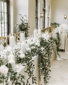 a long table with candles and greenery is set up for a formal dinner or reception