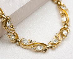 Vintage Crown Trifari gold wreath necklace with clear rhinestones. Very good condition (please see photos).  Ready to ship, gift wrap is included. DETAILS: ♥ material: gold tone metal, clear rhinestone  ♥ adjust. length: 13.75 - 15.75 inch / 35 - 40 cm ♥ type: adjustable choker ♥ signed: "Trifari (c)" ♥ from smoke-free home Please note that all items in my shop are vintage and may have signs of wear and age including scratches, tarnishing etc. Please see photos for quality.  -------------------- Wreath Necklace, Gold Wreath, Vintage Crown, Crown Trifari, April Birthstone, Clear Rhinestones, Gold Tone Metal, Necklace Gold, Gift Wrap