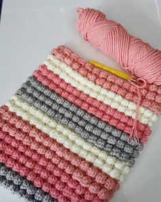 a crocheted dishcloth with yarn next to it