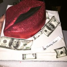 a cake with money and a red hat on it