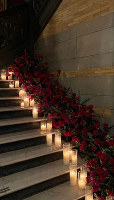 candles are lined up on the stairs with flowers