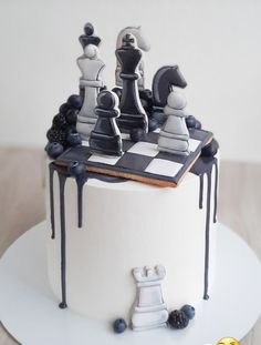 a cake decorated with chess pieces and blueberries