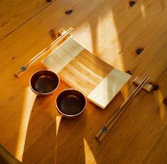 two wooden bowls and chopsticks on a table