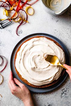 a person is spreading icing on top of a cake