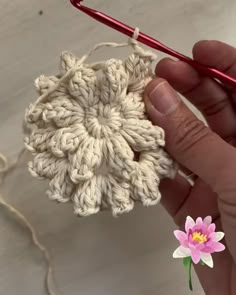 a crochet flower being worked on by someone