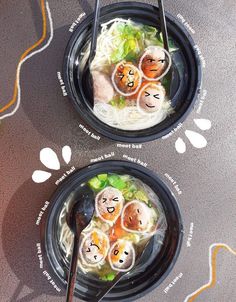 two black bowls filled with food and chopsticks on top of a gray table