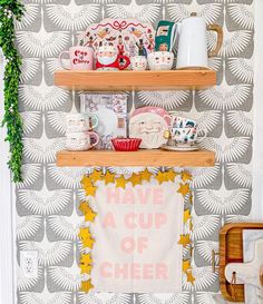 two shelves with cups and other items on them in front of a wallpapered background