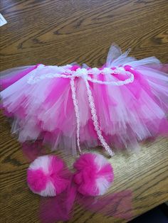 a pink and white tutu skirt, booties and headband on a table