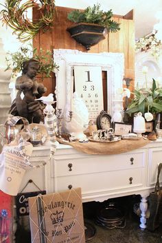 a white dresser topped with lots of different types of decorations and decorating items on top of it