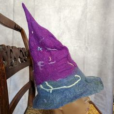 This Special Hat Is One Of A Kind And Perfect For The Witch Or Wizard On Your Life! It Was Made By Hand Through A Wet Felting Process (Wool Roving Transformed By Hot Water, Natural Soap, And A Lot Of Rubbing By Hand) And Is 100% Wool. It Doesn't Have A Huge Brim, But Does Have A Pointy Top. It Has Purple On The Top And Blue Gray On The Bottom With Embellishments Throughout. It Will Fit Most Women's Heads. For Reference, The Mannequin's Head Measures 21.5". The Hat Is About 14" Tall. While This Pointy Hat Is Similar To A Traditional Witch Hat, It Is Warm And Wonderful To Wear Throughout The Colder Months -- Not Just For Halloween. Unlike Most Costume Hats, It Is Wool Only -- No Gl Witchy Hat, Wool Roving, Mannequin Heads, Costume Hats, The Witch, Wet Felting, Blue Wool, Witch Hat, Natural Soap