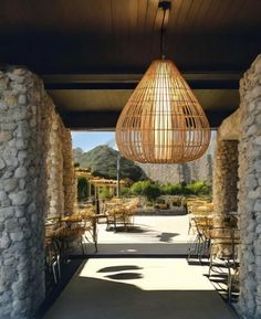 an outdoor area with tables and chairs under a light fixture that is hanging from the ceiling