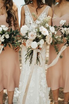 three bridesmaids holding bouquets in their hands