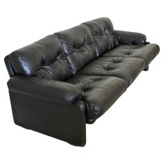 a black leather couch sitting on top of a white floor