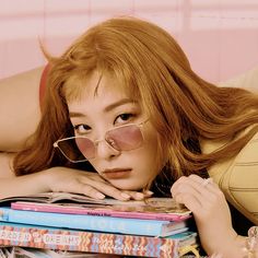 a woman laying on top of stack of books