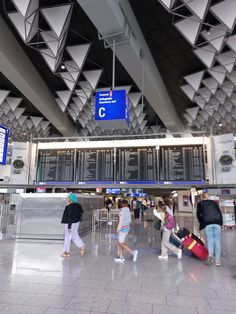 people are walking through an airport with their luggage