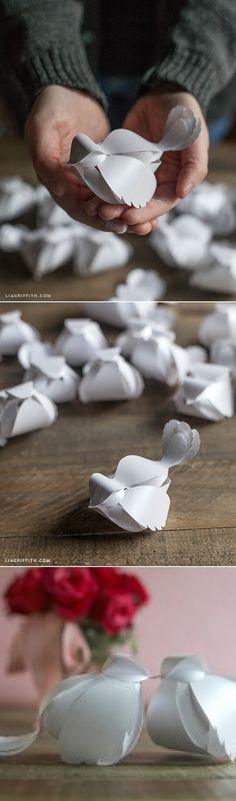 white origami flowers sitting on top of a wooden table