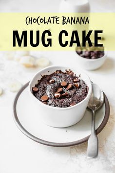 chocolate banana mug cake in a white bowl on a plate with a spoon and fork