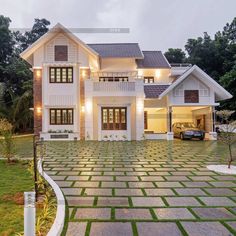 a large white house sitting on top of a lush green field