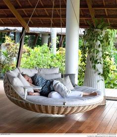 a person laying in a hanging chair on a wooden floor with the words outdoor porch bed above it