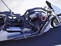 the motorcycle is parked on the pavement with its engine in it's side car