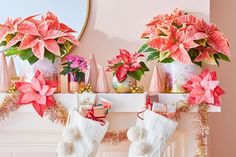 christmas stockings with poinsettis hanging from the mantel decorated with pink flowers