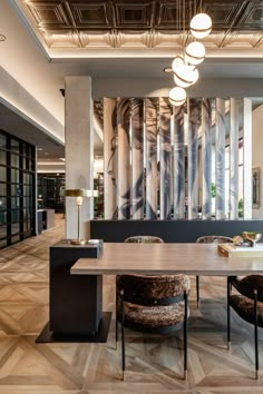 an elegant dining room with modern chairs and wood table in front of large wall art