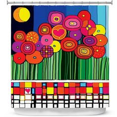 a colorful shower curtain with flowers and grass in the foreground, against a blue sky