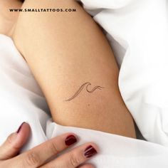 a woman's arm with a small wave tattoo on the left side of her body