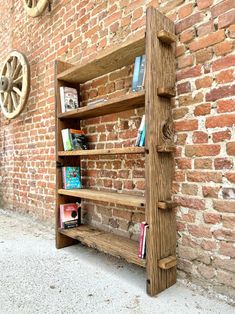 a wooden book shelf sitting next to a brick wall