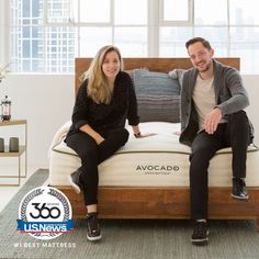 a man and woman sitting on top of an avocado mattress in a living room