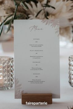 a menu card sitting on top of a table next to some candles and vases