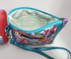 a small purse with an attached wrist strap next to a red cell phone case on a white surface